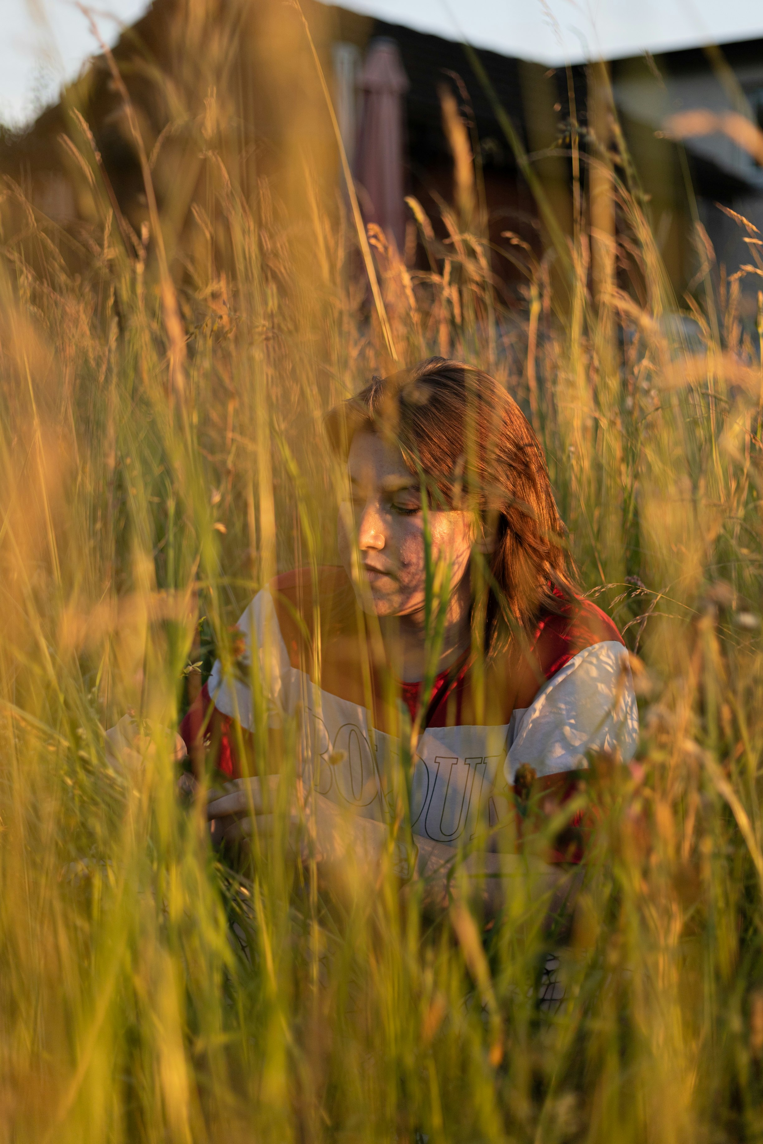 woman in white long sleeve shirt standing on wheat field during daytime